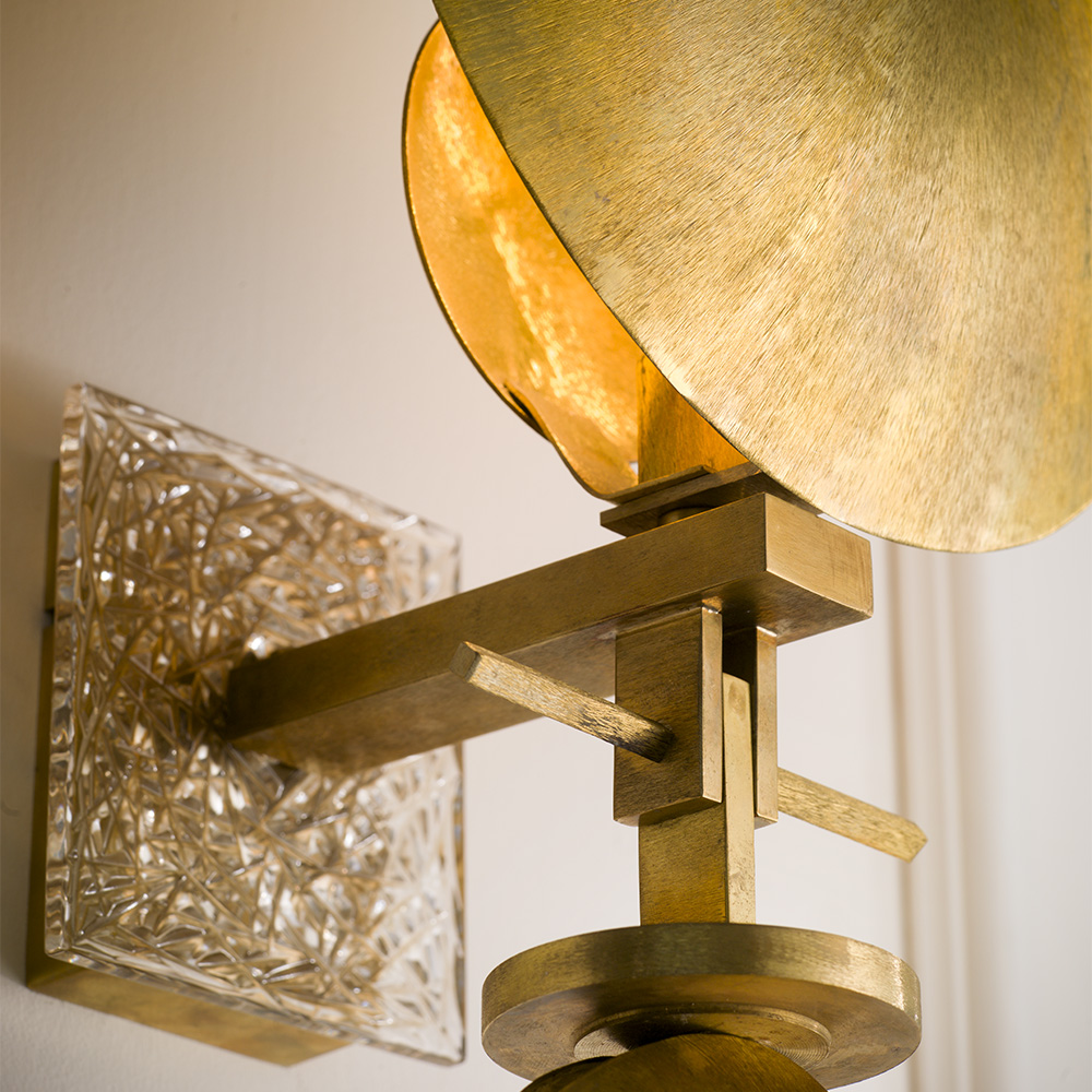 Wall lamp in natural brass frosted in “Fabric Effect”. Crystal detail on the back.